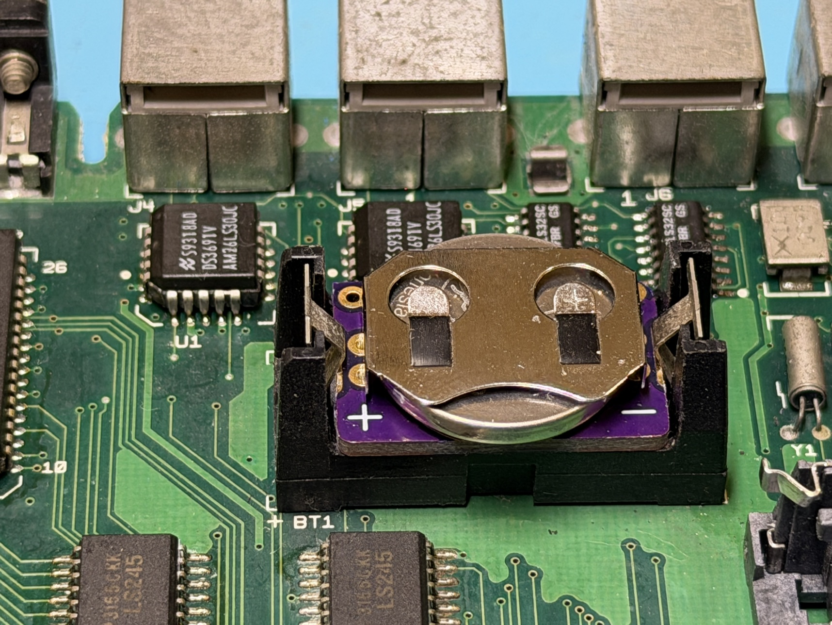 Closeup of a CR2032 battery installed in a Classic Macintosh logic board.